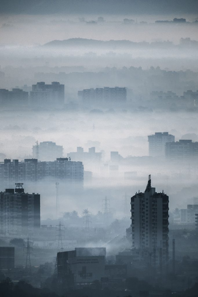 Ciudad de la India muy contaminada, repleta de torres de edificios y cubierta por una niebla densa.
